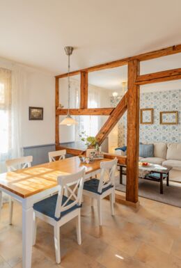 Innenaufnahme Zimmer mit Fachwerkbalken, Esstisch und Sofa