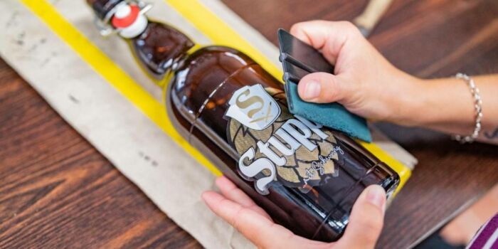 Beklebung einer Flasche mit dem Etikett der Stupps Brauerei in Steinbach